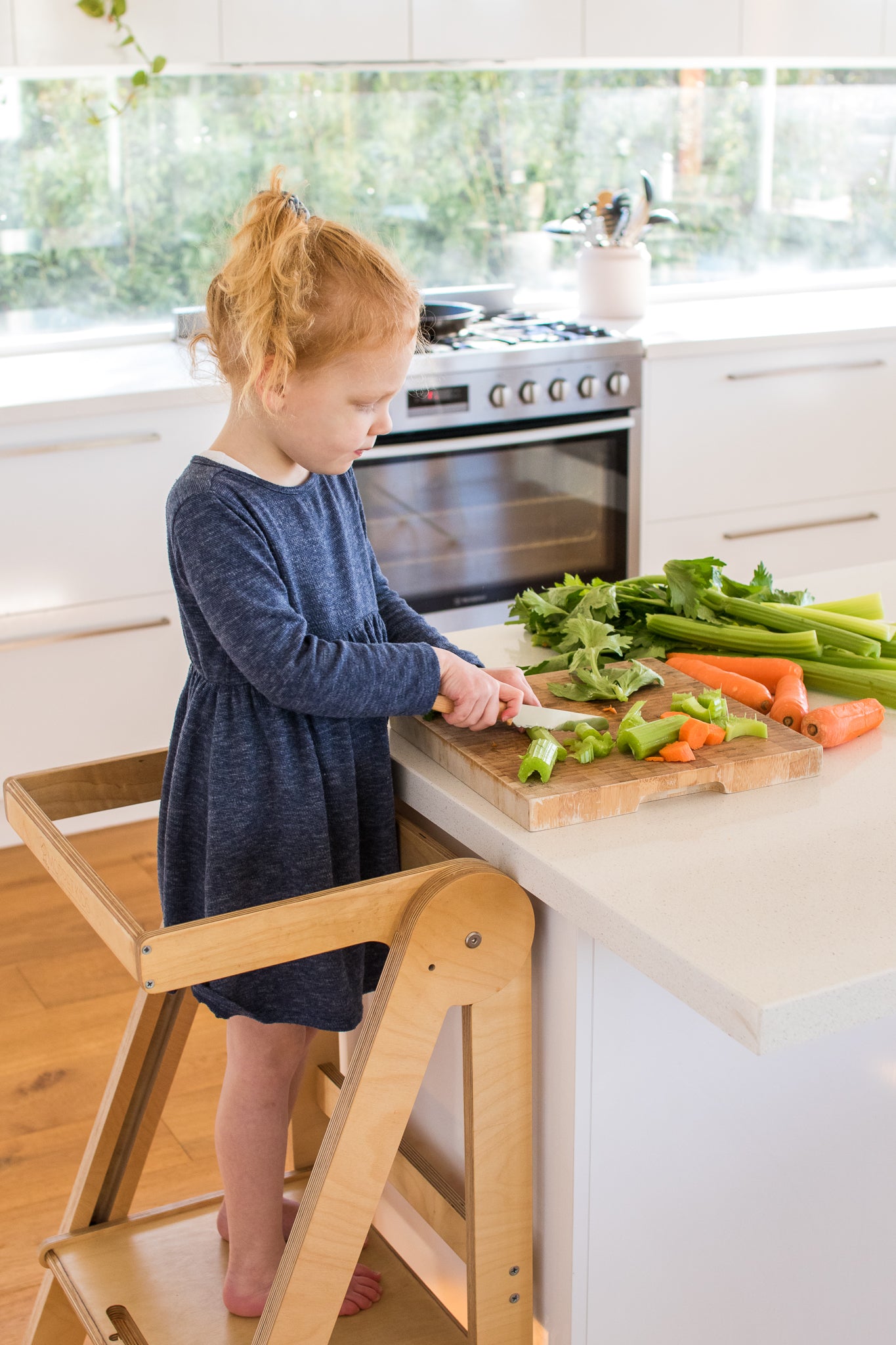 Kids cooking in the kitchen on a Folding Learning Tower