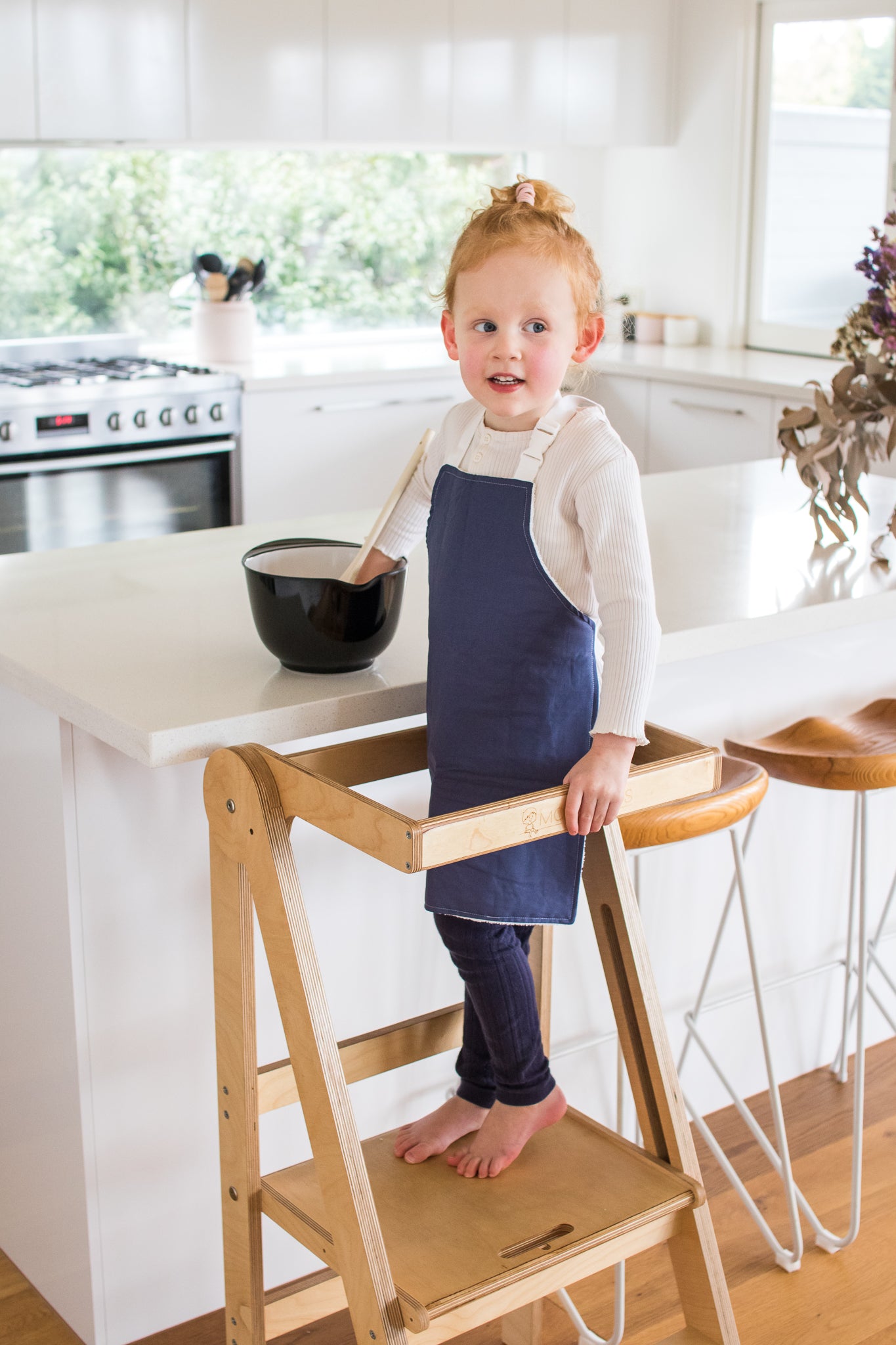 Handmade slate blue apron on child on Folding Learning Tower