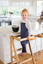 Load image into Gallery viewer, Handmade slate blue apron on child on Folding Learning Tower
